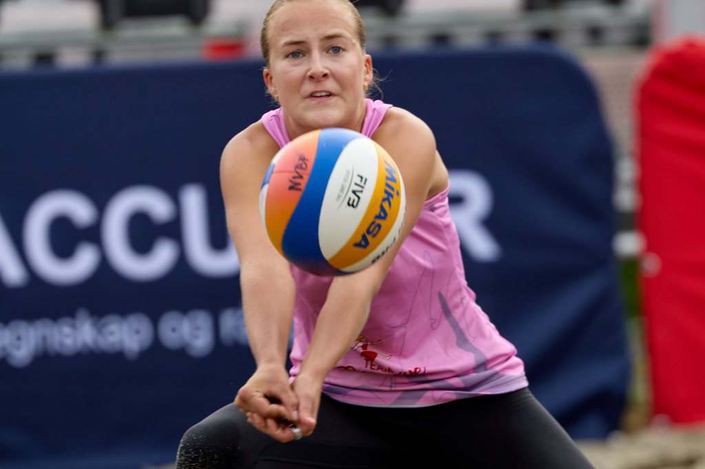 En kvinne som spiller volleyball, klarer å ta imot en ball i en spillscene.