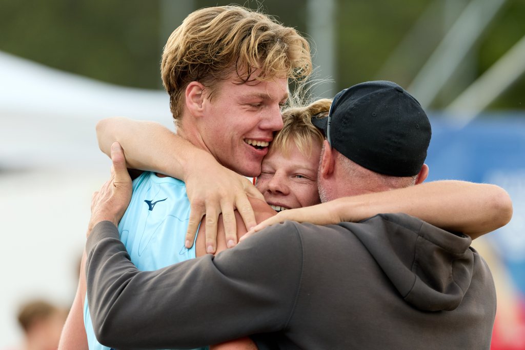 Tre personer omfavner hverandre i glede, med smil og latter, etter å ha oppnådd noe spesielt.